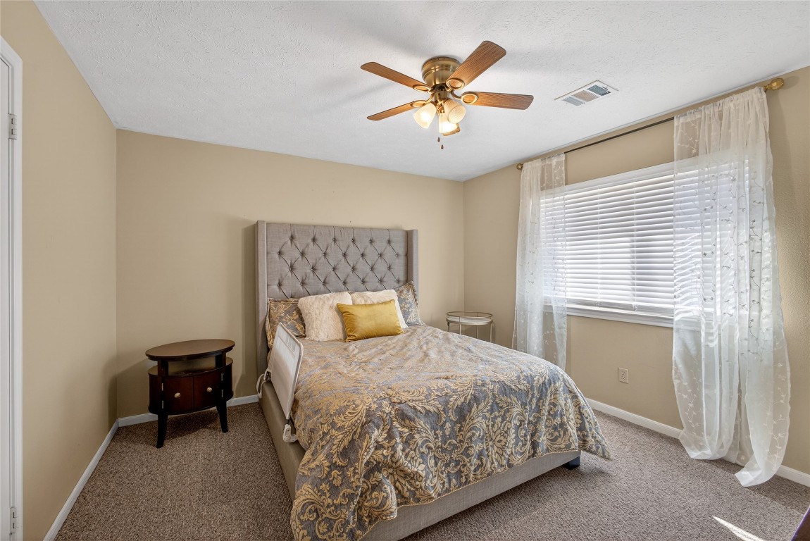 19115 Keyturn Lane Humble, TX 77346 - Photo 23 of 32 a bedroom with a bed and a ceiling fan