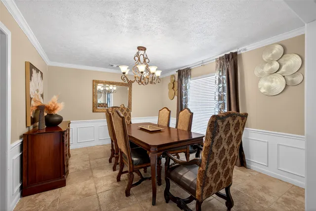 a view of a dining room with furniture and chandelier