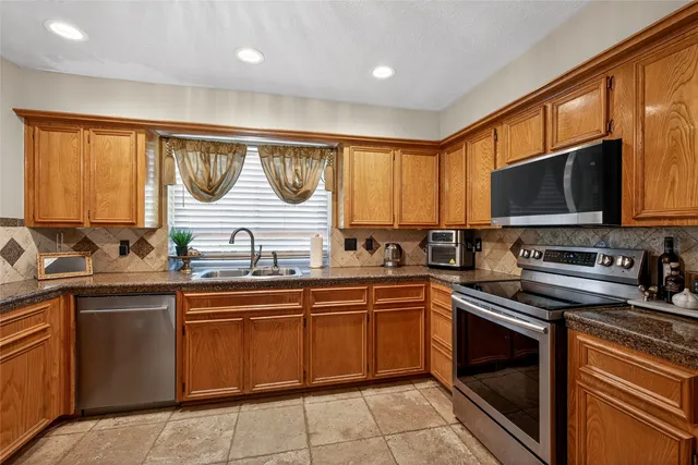 a kitchen with a sink stove top oven and cabinets