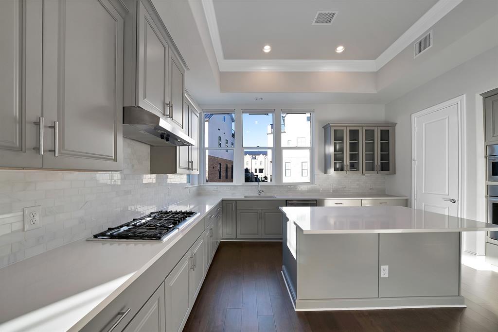 5437 Patterson Street Irving, TX 75039 - Photo 15 of 40 Kitchen with dark wood finished floors, recessed lighting, gray cabinets, glass insert cabinets, and stainless steel gas cooktop