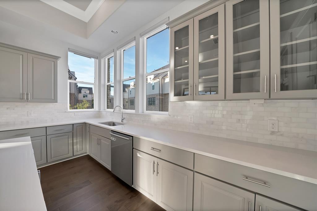 5437 Patterson Street Irving, TX 75039 - Photo 17 of 40 Kitchen featuring gray cabinets, glass fronted cabinets, dark wood-style flooring, and stainless steel dishwasher