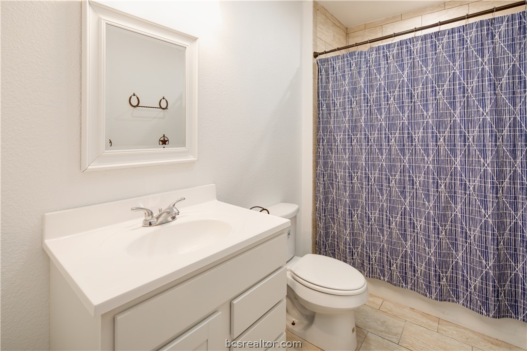 1204 East 28th Street Bryan, TX 77803 - Photo 15 of 22 a bathroom with a sink a toilet and mirror