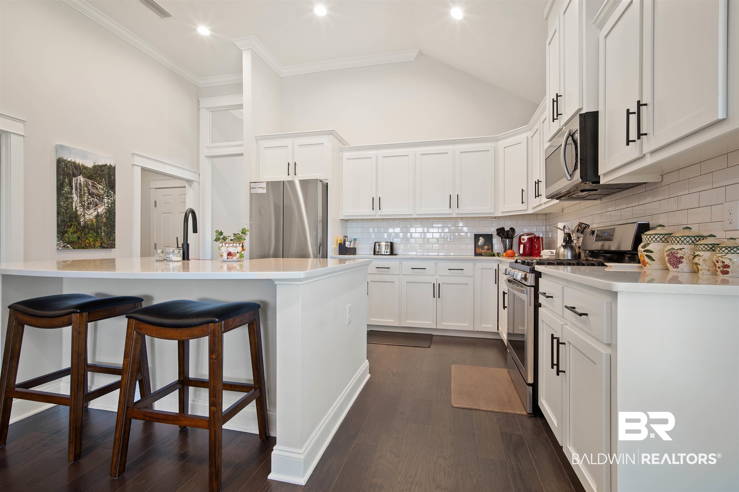 969 Charleston Loop Fairhope, AL 36532 - Photo 8 of 30 Kitchen with white cabinets, decorative backsplash, appliances with stainless steel finishes, and dark hardwood / wood-style floors