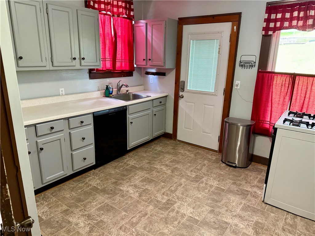237 Beech Road Weirton, WV 26062 - Photo 10 of 24 Kitchen with black dishwasher, a sink, white gas stove, light countertops, and baseboards