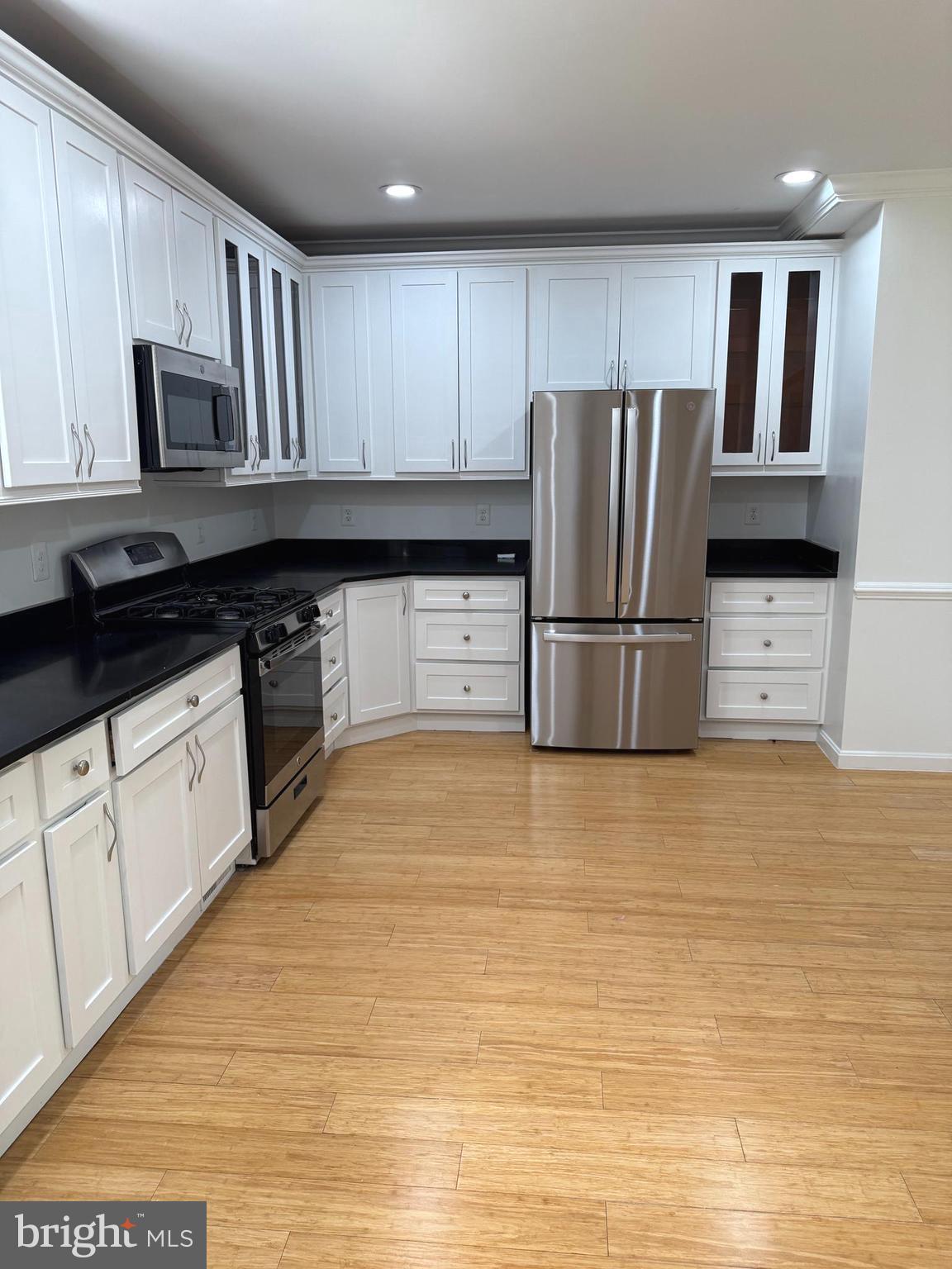 1242 Anacostia Road Southeast Washington, DC 20019 - Photo 8 of 27 a kitchen with granite countertop a refrigerator a stove a sink a microwave and cabinets