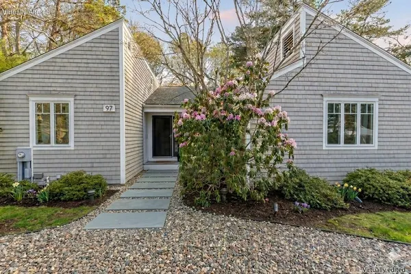 a front view of a house with a yard and trees