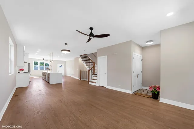 a view of a livingroom with furniture wooden floor and a ceiling fan