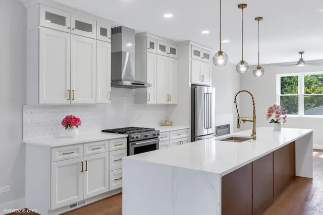 a kitchen with white cabinets and sink