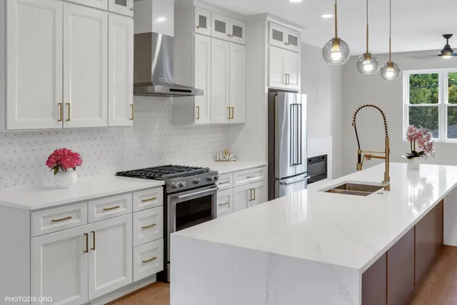 a kitchen with stainless steel appliances granite countertop a sink a stove and a refrigerator