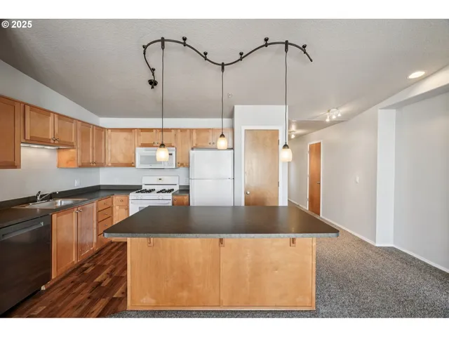 a kitchen with stainless steel appliances granite countertop a sink a refrigerator and a granite counter tops