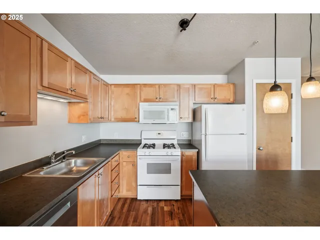 a kitchen with a stove cabinets and wooden floor