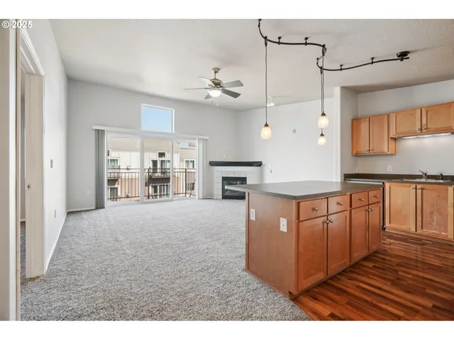 a kitchen with stainless steel appliances granite countertop a refrigerator a oven and a wooden cabinets