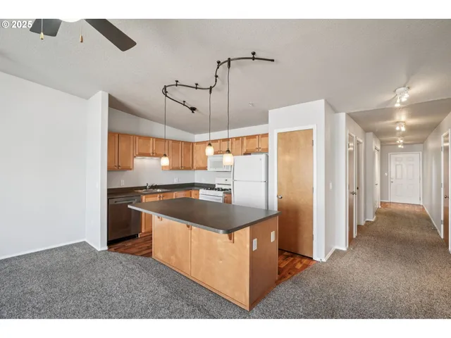 a kitchen with stainless steel appliances granite countertop a sink and a refrigerator