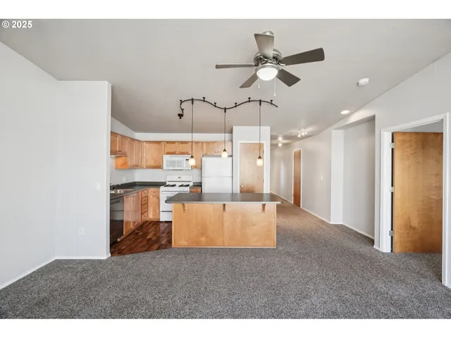 a view of a kitchen and kitchen with stainless steel appliances wooden floor