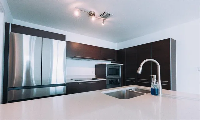 a kitchen with a refrigerator and a sink