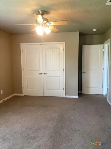 an empty room with closet and chandelier fan