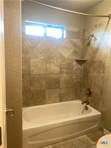 a bathroom with a white bath tub and a shower