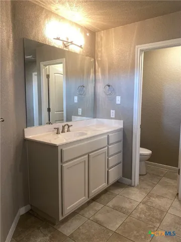 a bathroom with a double vanity sink mirror and toilet