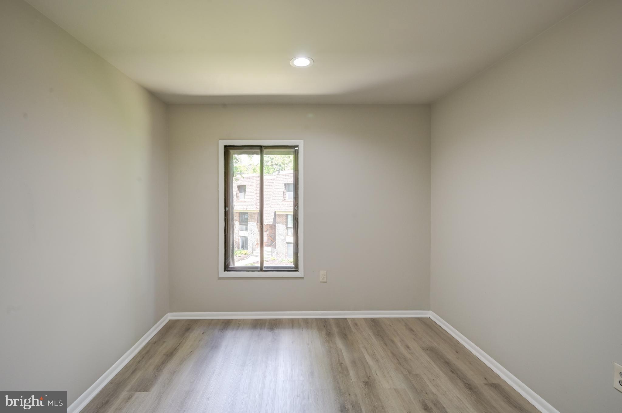 5241 West Running Brook Road, Unit 302 Columbia, MD 21044 - Photo 11 of 32 an empty room with wooden floor and windows