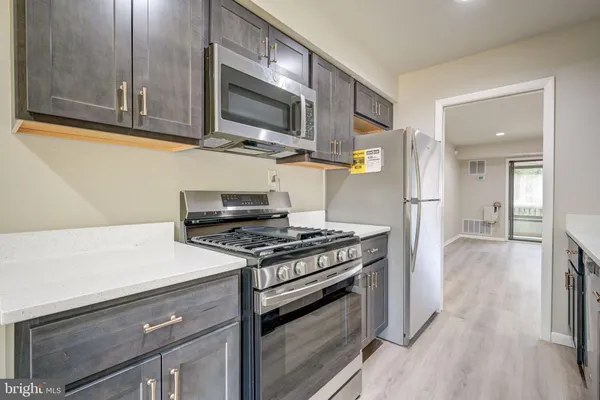 a kitchen with stainless steel appliances granite countertop a stove and a microwave