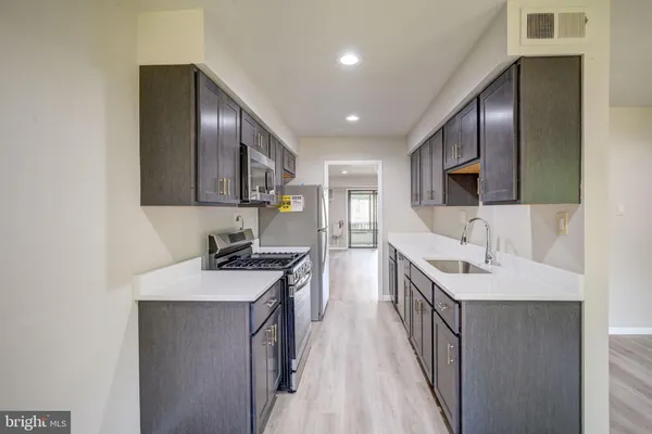 a kitchen with a sink appliances and cabinets