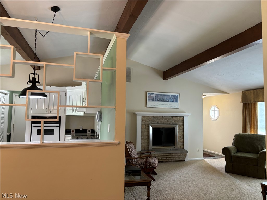 5595 Meister Road Mentor, OH 44060 - Photo 3 of 26 Carpeted living room featuring lofted ceiling with beams and a brick woodburning fireplace