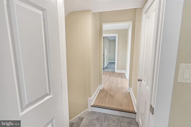 a view of a hallway with wooden floor and closet