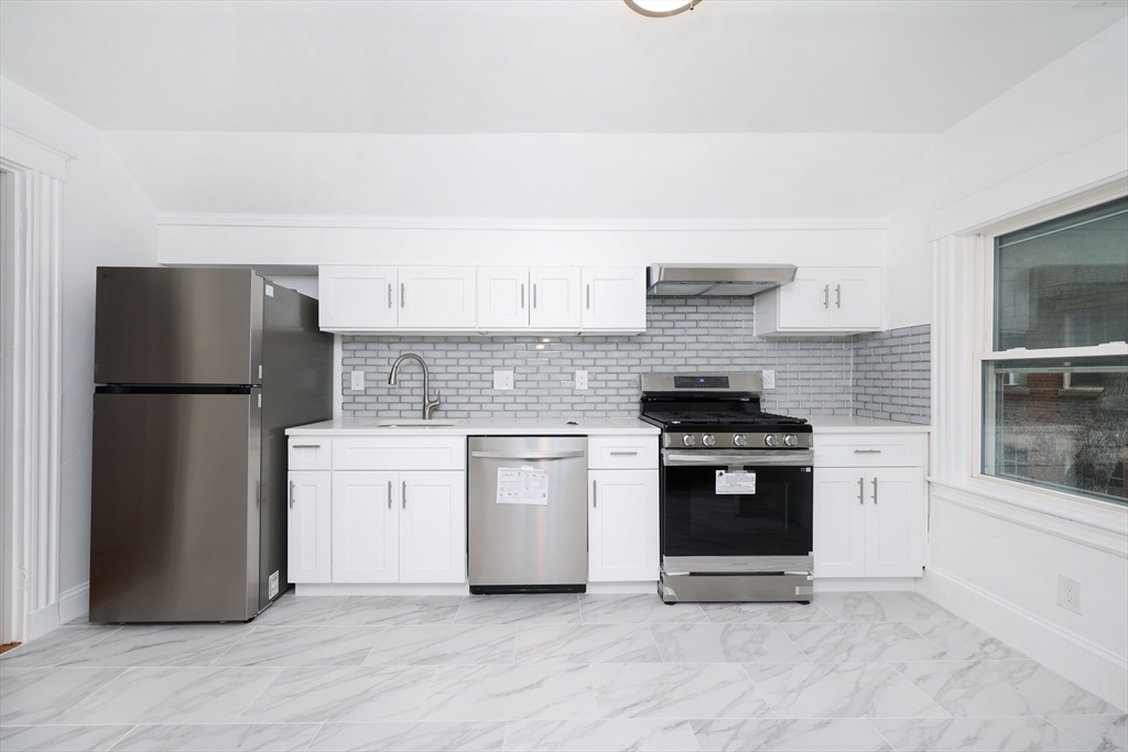 5 Chauncy Street, Unit 3 Cambridge, MA 02138 - Photo 1 of 11 a kitchen with granite countertop white cabinets and stainless steel appliances