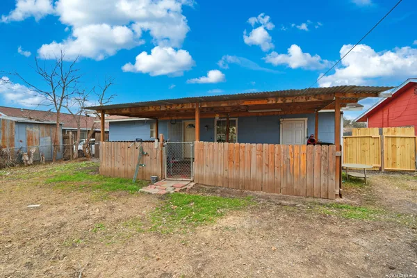 a view of a house with backyard and wooden fence