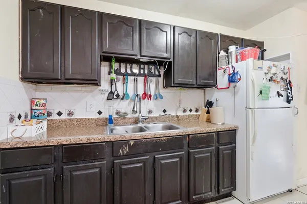 a kitchen with granite countertop a sink stove and cabinets