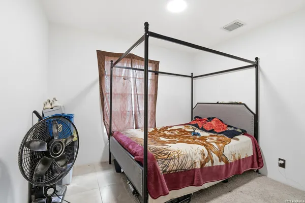 a bed sitting in a bedroom next to a window
