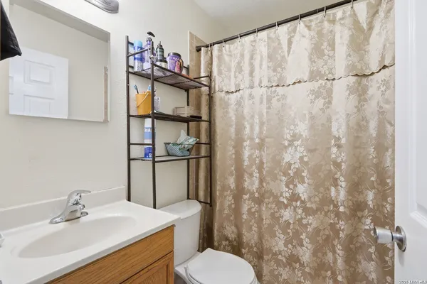 a bathroom with a sink vanity mirror and toilet