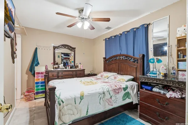 a bedroom with a bed and a mirror on the dresser