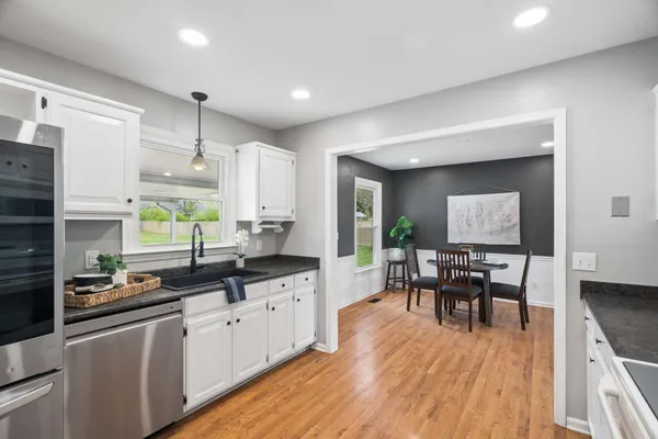 a kitchen with stainless steel appliances granite countertop sink stove top oven and cabinets
