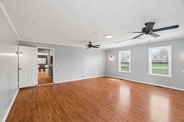 a view of a livingroom with a ceiling fan window and wooden floor
