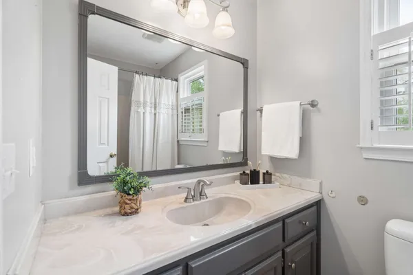 a bathroom with a granite countertop sink a mirror and a shower