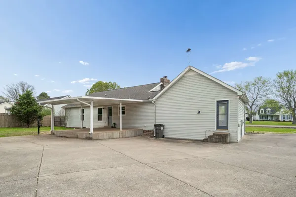 a view of a house with a backyard and a small yard