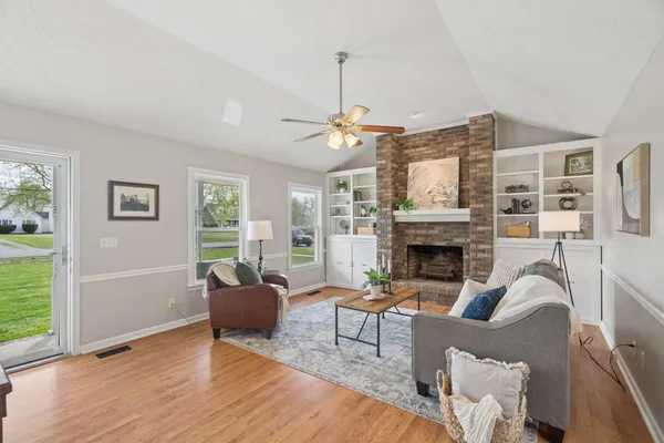 a living room with furniture a large window and a fireplace