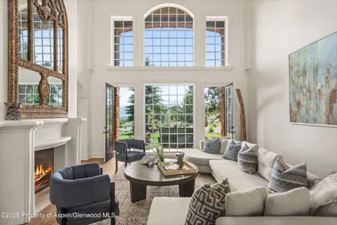 a living room with furniture a fireplace and a large window
