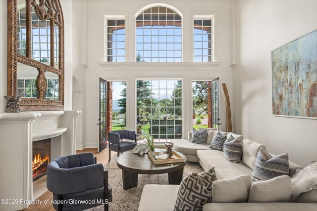 a living room with furniture a fireplace and a large window