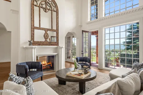 a living room with furniture fireplace and a large window