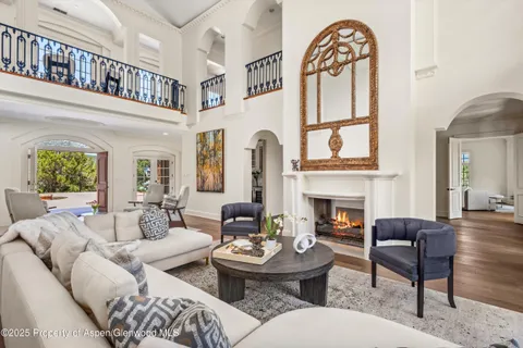 a living room with furniture a fireplace and a large window