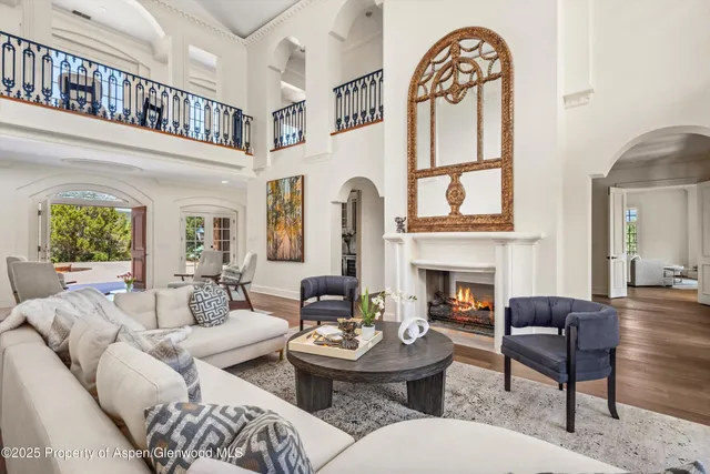 a living room with furniture a fireplace and a large window