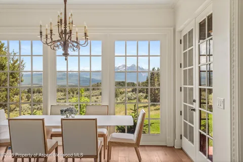 a view of a dining room with furniture a chandelier and wooden floor