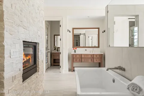 a bathroom with a tub a double vanity sink and a mirror