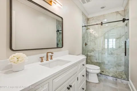 a bathroom with a sink a toilet and shower