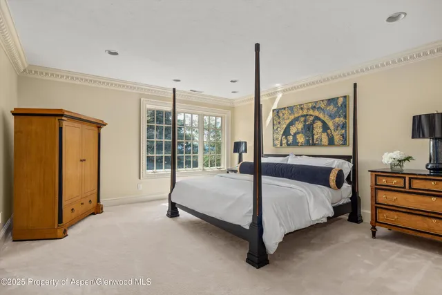 a spacious bedroom with a bed and a dresser next to a window