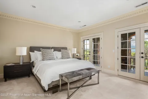 a bedroom with a bed and a large window