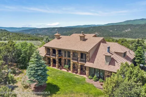 an aerial view of house with yard and mountain view