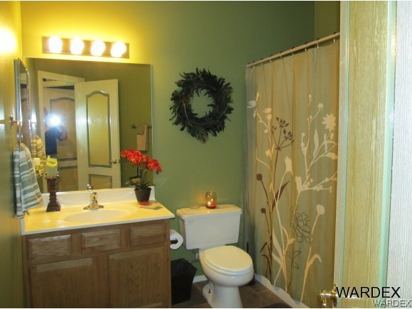 2976 Ranch House Road Bullhead City, AZ 86442 - Photo 18 of 29 a bathroom with a sink and mirror with toilet